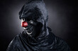 Scary clown showing his teeth over dark misty background