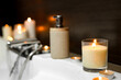 Burning candles on edge of bath indoors, closeup. Romantic atmosphere