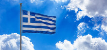 Greece Sign Symbol. Greek National Official Flag On Flagpole Waving In The Wind, Blue Sky