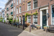 Amsterdam City Paved Alley. Brick Wall House And Bicycle Parked In Front, Holland Netherlands.