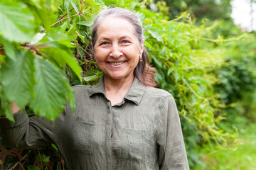 Poster -   60-year-old woman in   green dress outdoors in summer.