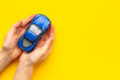 Leinwandbild Motiv Car insurance concept. Toy car in hands, top view