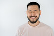 © LIGHTFIELD STUDIOS - portrait of asian man with beard and closed eyes smiling isolated on grey.
