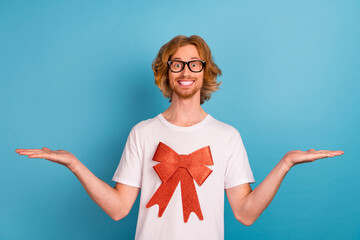 Sticker - Photo of handsome guy arms demonstrate empty space vs scales isolated on blue color background