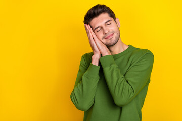 Wall Mural - Photo of dreamy tired guy wear green sweater arms cheek sleeping empty space isolated yellow color background