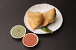 Indian favourite snack samosa served with red and green chutney
