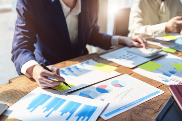 Wall Mural - A group of business people working together on a new project to analyze budgets and manage investment risks in today's profit boosting for marketing in the conference room