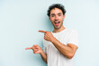 © Asier - Young caucasian man isolated on blue background pointing with forefingers to a copy space, expressing excitement and desire.