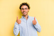 © Asier - Young caucasian man isolated on yellow background raising both thumbs up, smiling and confident.