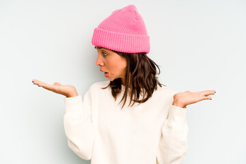 Wall Mural - Young hispanic woman isolated on blue background holding a copy space on a palm.