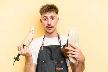 Wall Mural - Young shoemarket man isolated on yellow background