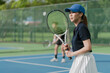 Asian young couple playing tennis on a tennis outdoor court on a bright sunny day.