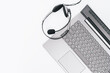 Top view of slim laptop with headset on white desk. Monochrome background. Distant learning. working from home, online courses or support. Audio podcast headphones . Helpdesk or call center
