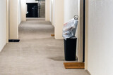Fototapeta Na ścianę - Concierge valet door to door trash collection services for apartment with garbage in bin and plastic bags for pick up in residential building hallway corridor hall