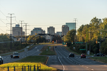 Reston, USA - October 18, 2021: Reston, northern Virginia town center office building architecture in sunrise morning view of cityscape skyline and street road with traffic light and cars