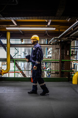 Oil refinery worker walking in production plant.