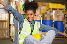 Two Girls Warehouse Workers Relax And Play During The Break Of The Day.