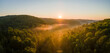 © bilanol - Vibrant foggy morning over dark forest trees at bright summer sunrise. Amazingl scenery of wild woodland at dawn