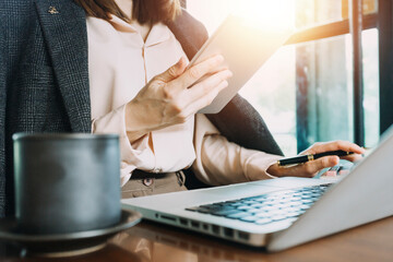 businesswoman hand working with laptop computer, tablet and smart phone in modern office with virtual icon diagram at modernoffice in morning light