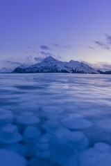 Sticker - Vertical shot of the frozen Abraham Lake with a mountain in the background in Alberta, Canada