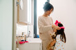 © Drobot Dean - Asian mother wearing headband on her daughter in bathroom