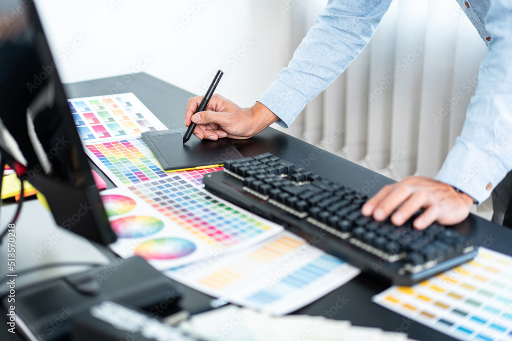 Young creative graphic designer working on color selection and drawing ...