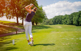 Fototapeta Na sufit - Sporty woman golfer player doing golf swing tee off on the green evening time, she presumably does exercise. Healthy Lifestyle Concept. Healthy Sport.