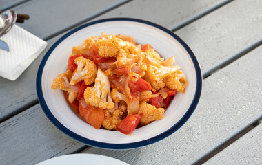 Wall Mural - Spicy cauliflower with tomato in szechuan sauce on a plate