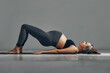 © Georgii - Full Body Portrait Of Pregnant Woman Doing Yoga On Exercise Mat. Isolated on gray background