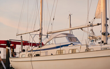 Wall Mural - White two masted cruising sailboat standing on land in a yacht club. Service, repair, winterization, transportation, sport, recreation, leisure activity