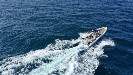 Aerial drone photo of luxury rigid inflatable speed boat cruising in high speed in Aegean deep blue sea, Greece