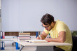 © Elnur - Young male student preparing for exams in the classroom