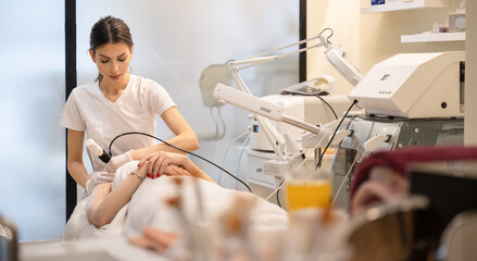 Wall Mural - Female beautician giving anti-aging rejuvenation procedure to client at beauty salon