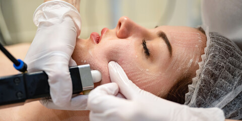 Wall Mural - Close up of beautiful young woman getting rejuvenation treatment in beauty salon