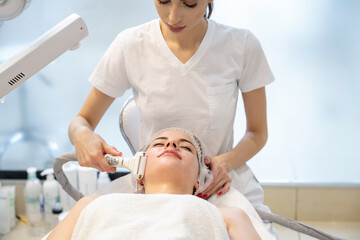 Wall Mural - Young woman enjoying lifting and rejuvenating procedure in beauty salon.