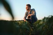© Serhii - Agronomist inspecting soya bean crops growing in the farm field. Agriculture production concept. young agronomist examines soybean crop on field in summer. Farmer on soybean field.