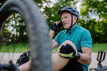 Wall Mural - Active senior man calling for help after his bicycle accident.