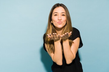 Wall Mural - Good looking Caucasian brunette blowing a kiss in a studio