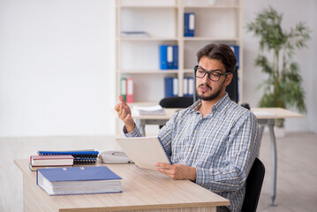 Young male employee sitting in the office