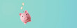 pink piggy bank with coins falling inside - savings concept