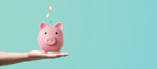 Man Holding A Pink Piggy Bank With His Hand And Depositing Coins - Savings Concept