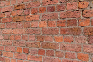 Canvas Print - Old exterior European brick wall texture background in an English bond brickwork pattern, with weathered bricks in varying shades of red