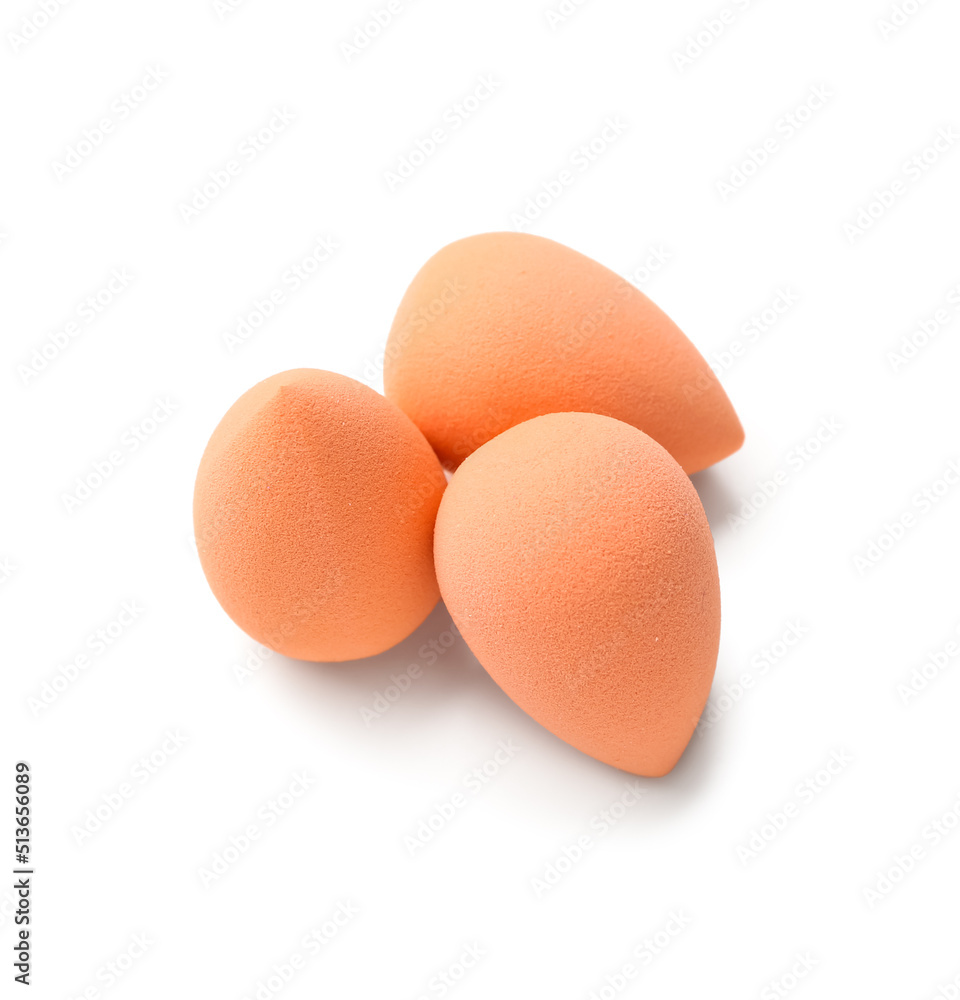 Orange makeup sponges on white background