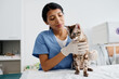 © pressmaster - Young adult Hispanic woman enjoying working in modern vet clinic doing medical check-up for beautiful cat