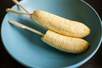 Wall Mural - peel banana close up in a blue bowl