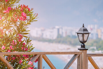 Wall Mural - Famous Konyaalti beach, scenic panoramic view from a view point. Decorative lantern and wooden fence and blooming flowers in spring time. Travel destinations of mediterranean riviera