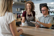 © gpointstudio - Caucasian man with down syndrome taking order in the cafe using a digital tablet