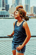 © Carlos David - Portrait beautiful young adult woman afro hairstyle with Manhattan New York City skyline in the background outdoors shot