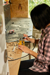 Wall Mural - Woman using power working grinder machine, female hand grinds a metal nuts