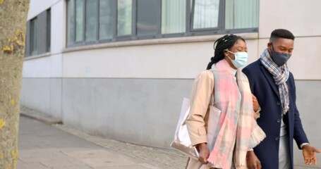 Wall Mural - Couple Wearing Face Masks Chatting and Walking Past Building 